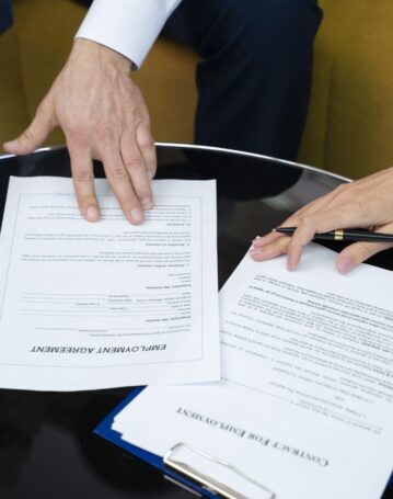 high-angle-hands-signing-documents